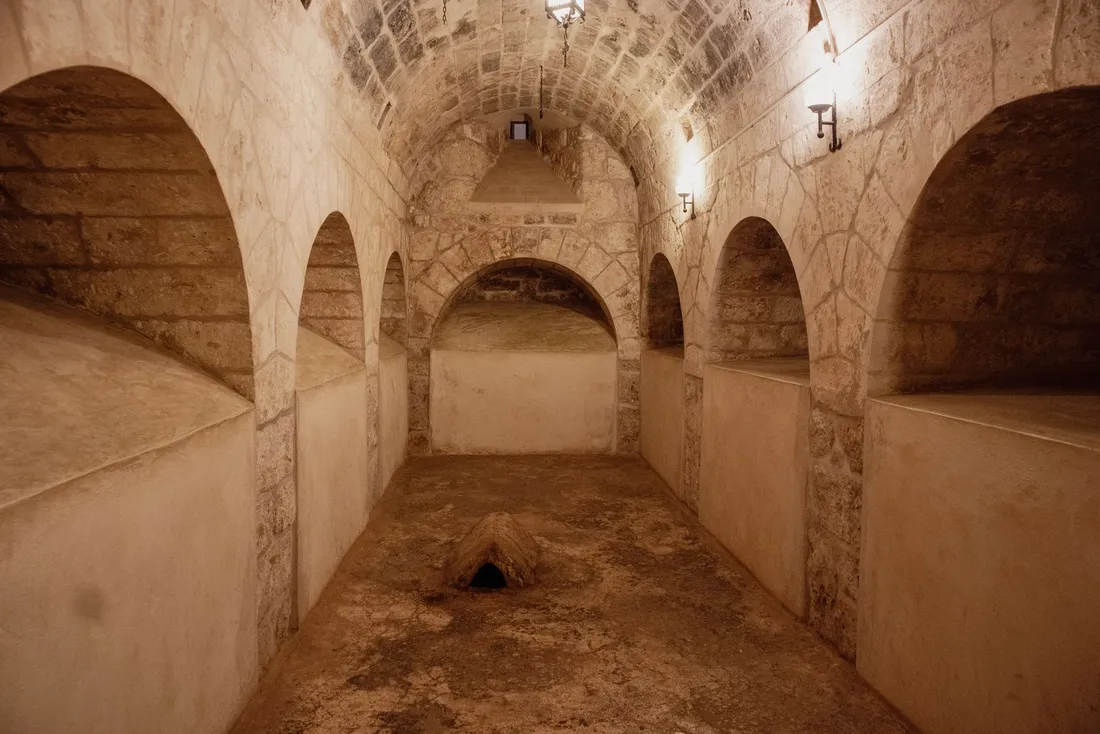 Sous-sol voûté en pierre aux murs enduits en partie basse, alcôves et sol brut (Les Epesses, Vendée)