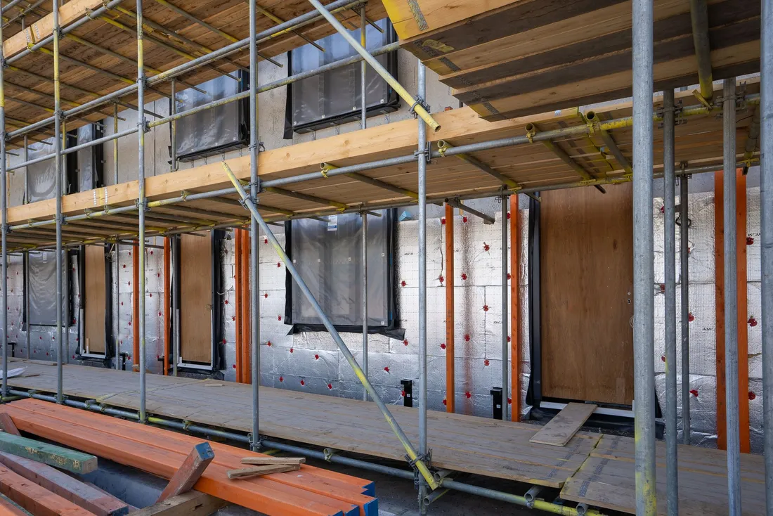 Façade sous échafaudage, panneaux isolants fixés sur les murs avant l'enduit de finition